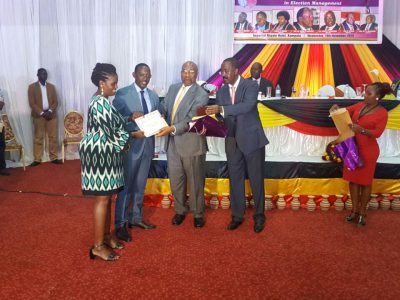 Kosiya receiving an award from Hon Ruhakana Rugunda