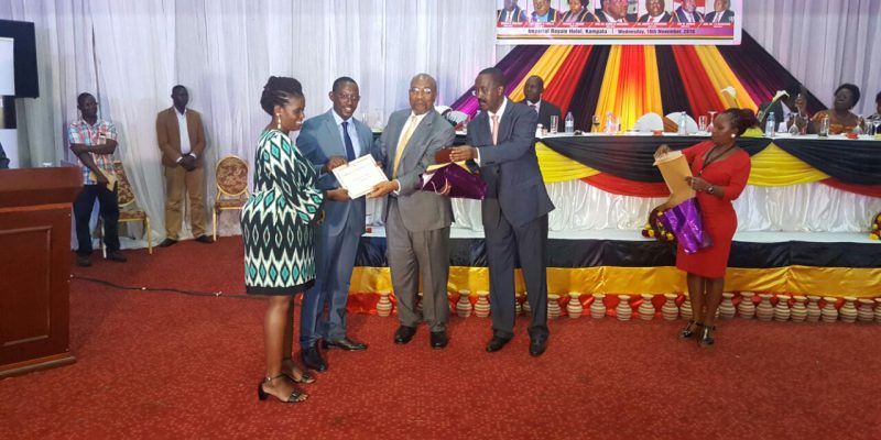 Kosiya receiving an award from Hon Ruhakana Rugunda